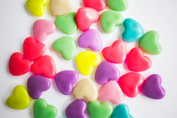 Multi-colored plastic hearts on a white background. Background for Valentine's day