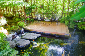 Chairs and wooden table with garden pond in forest,garden concept,copy space.