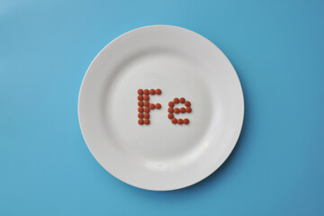 The mineral "iron" in tablets on a white plate. Iron deficiency in the body