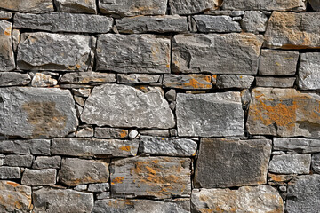 Obraz premium Weathered stone wall covered in orange lichen