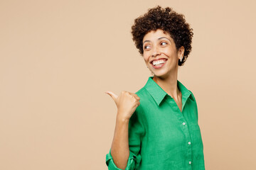 Young happy fun woman of African American ethnicity wear green shirt casual clothes point thumb...