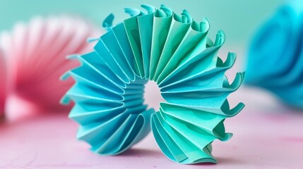   A tight shot of a blue-green origami figure against a pink backdrop, surrounded by additional origami pieces in the background