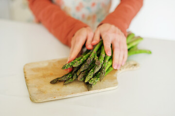 female hands keep of asparagus, focus on a asparagus