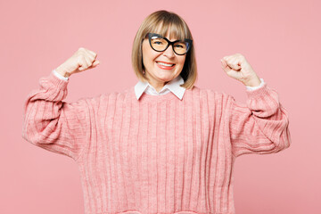 Elderly woman 50s years old wear sweater shirt casual clothes glasses showing biceps muscles on...