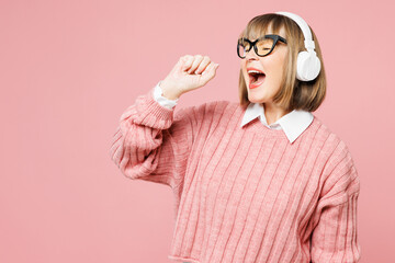 Elderly woman 50s years old wear sweater shirt casual clothes glasses listen to music in headphones...