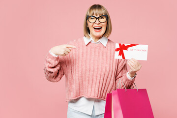 Elderly young woman wears casual clothes hold point on package bags after shopping gift certificate...