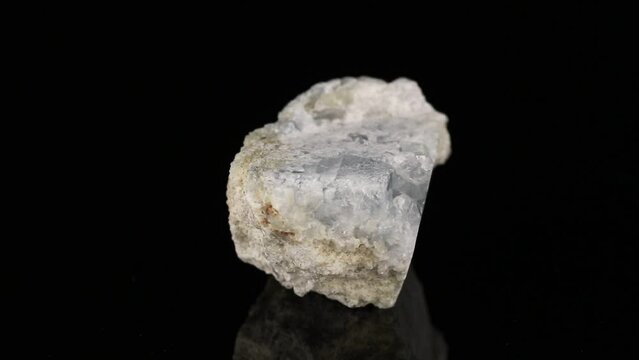 Polished mineral stone Celestine rotates in a circle on a black background