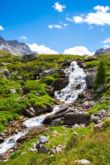Fototapeta na wymiar Water stream in French Alps. Peisey valley, Savoie, France. Beautiful nature mountain valley landscape background. Earth beauty, eco-planet, environment and ecology concepts.