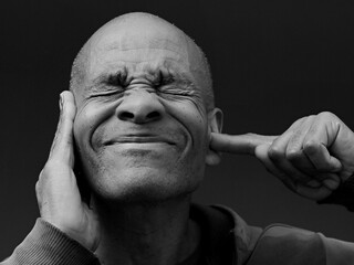 deaf man suffering from deafness and hearing loss on grey background with people stock photo	