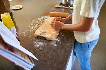 Woman, hands and baking with flour on board in kitchen for new recipe, cookbook or lesson at home....