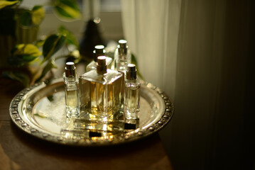 perfume bottle by a window on a silver tray