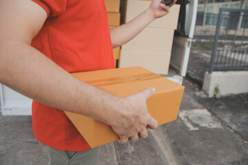 Asian delivery express courier young man use giving boxes to woman customer he wearing protective...