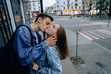 Fototapeta premium beautiful and young lovers, guy and girl kissing and hugging. Happy Caucasian couple on first date in the city, smiling and relaxing