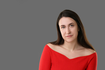 Obraz premium Portrait of beautiful young woman on grey background. Space for text