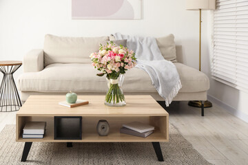 Beautiful bouquet of fresh flowers in vase on wooden coffee table indoors