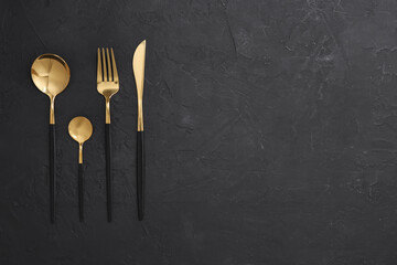 Beautiful cutlery set on black table, flat lay. Space for text - obrazy, fototapety, plakaty