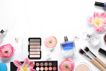 Flat lay composition with different makeup products and beautiful spring flowers on white...