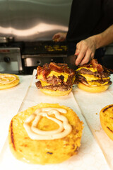 close up of a person serving a doble cheese burger with bacon