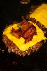 smashed burger with cheese and bacon on the grill
