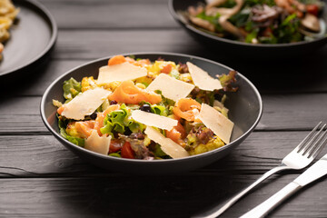 salad with salted salmon, lettuce, croutons and parmesan cheese with caesar dressing. Seafood salad on table background - obrazy, fototapety, plakaty