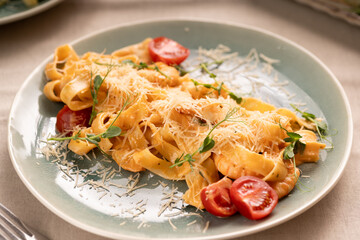 Fettuccine pasta with shrimp, tomatoes and herbs serving on plate, top view. Italian food concept