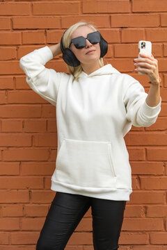 Stylish blonde woman taking a selfie with headphones