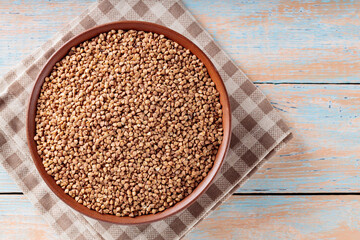 Dry Buckwheat Groats in Bowl on Wooden Table, Gluten-Free Diet, Top View, Copy Space
