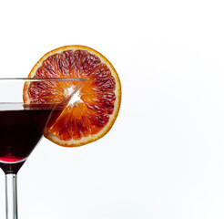 Dark purple drink in cocktail glass with slice of blood orange isolated on white background. Close up.
