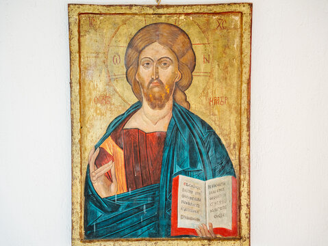 Ancient-looking Eastern Orthodox Christian Icon of Jesus Christ hangs on a white wall