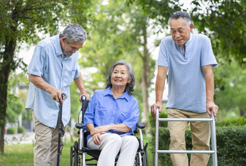 group of senior people with rehabilitation equipment enjoy talking together, friends spend their time in the park