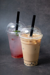 Two plastic glasses with bubble tea on dark background. Trendy summer drinks
