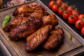 Delicious juicy chicken wings baked on the grill with salt, spices and herbs