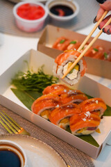 Sushi roll Philadelphia with salmon, smoked eel, avocado, cream cheese on black background. Sushi menu. Japanese food.