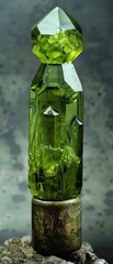 A green crystal is sitting on a rock