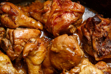 chicken breast pieces in a frying pan stewed in sauce and spices