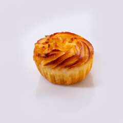 Delicate vanilla sweets lled with buttercream and candied citrus fruits topped with nut crumbs and yellow icing, presented isolated on white background