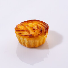 Delicate vanilla sweets lled with buttercream and candied citrus fruits topped with nut crumbs and yellow icing, presented isolated on white background