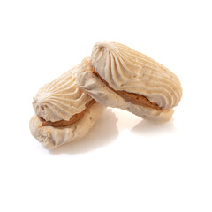 Delicate vanilla sponge rolls filled with buttercream and candied citrus fruits topped with nut crumbs and yellow icing, presented isolated on white background