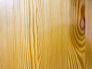 Close-up of a smooth yellow piece of wood with a small round knot in the center. The wood grain is visible and there are minor imperfections on the surface such as small scratches or dents
