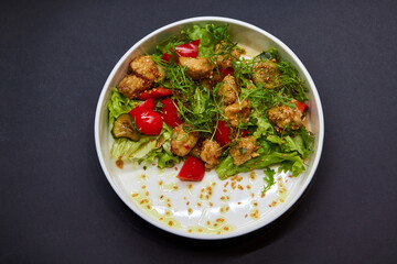 White bowl with lettuce, tomatoes, and chicken salad