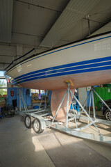 A sailboat is in the paint shop for painting