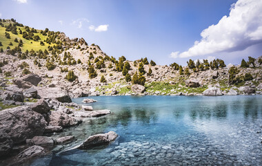 Fototapeta na wymiar Mountain panorama, landscape with rocky peaks and blue turquoise lake Ziyorat in the Fan Mountains in Tajikistan, on a sunny summer day