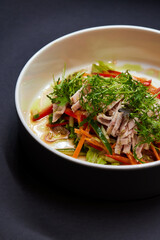 A white plate with a vegetable salad, a staple food on the table