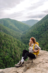 Naklejka na ściany i meble Young tourist woman on top of a mountain. Scenery of the majestic mountains. Active lifestyle.
