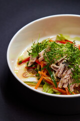 A white plate with a vegetable salad, a staple food on the table