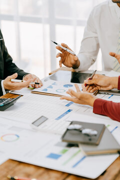 Two people are looking at a graph on a table. One of them is holding a pen. The graph shows a comparison of different data points