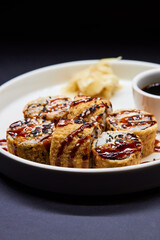 Sushi dish on white plate with sauce, table setting