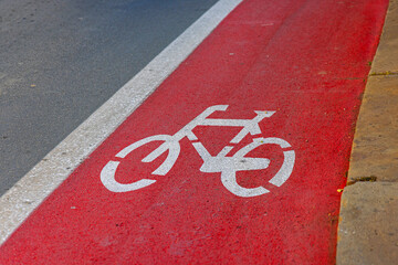 Painted Bright Red Bike Lane Stencil Sign at Street in City