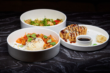 Close up of three bowls with fish ball, leaf vegetable, and plate on table