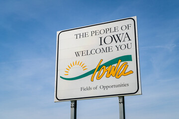 Iowa welcome roadside sign against blue sky at state border with Missouri,  travel concept